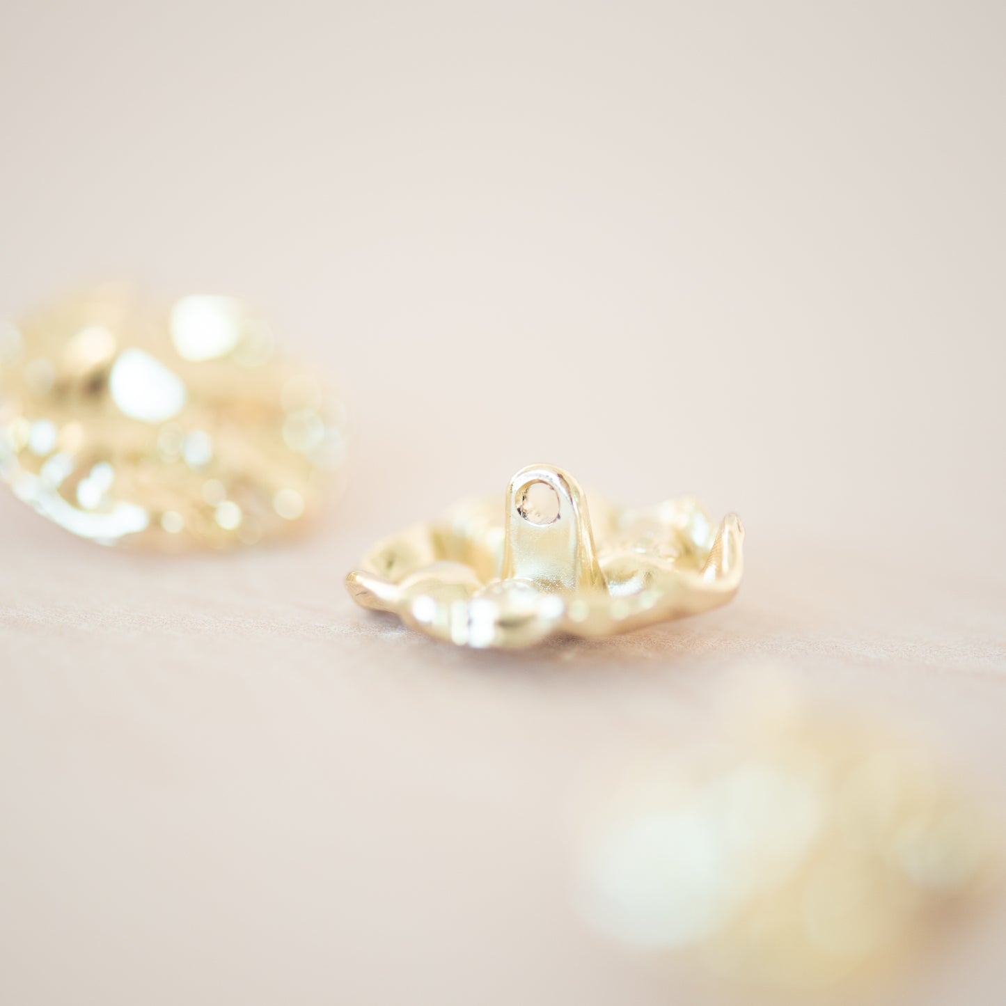 Gold asymetric metal button