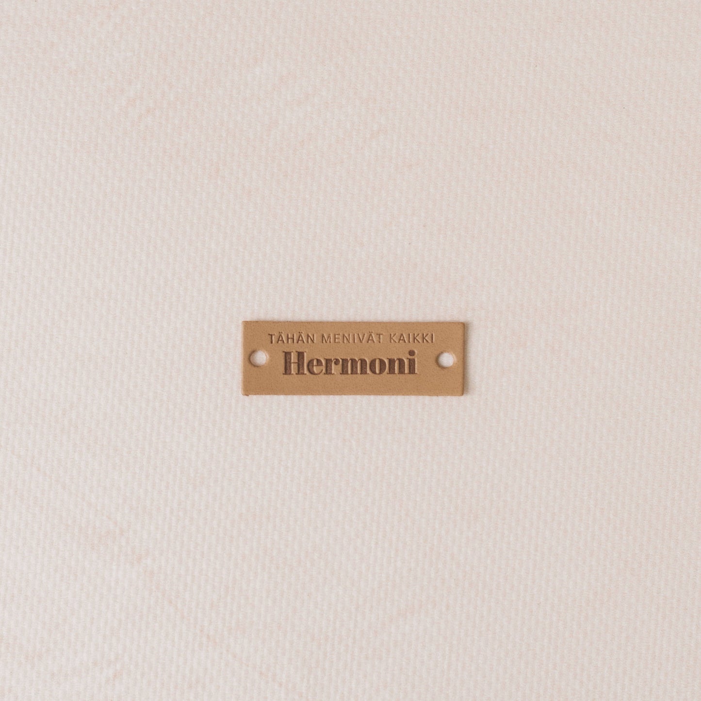 Brown label with 'Hermoni' text on a textured beige background