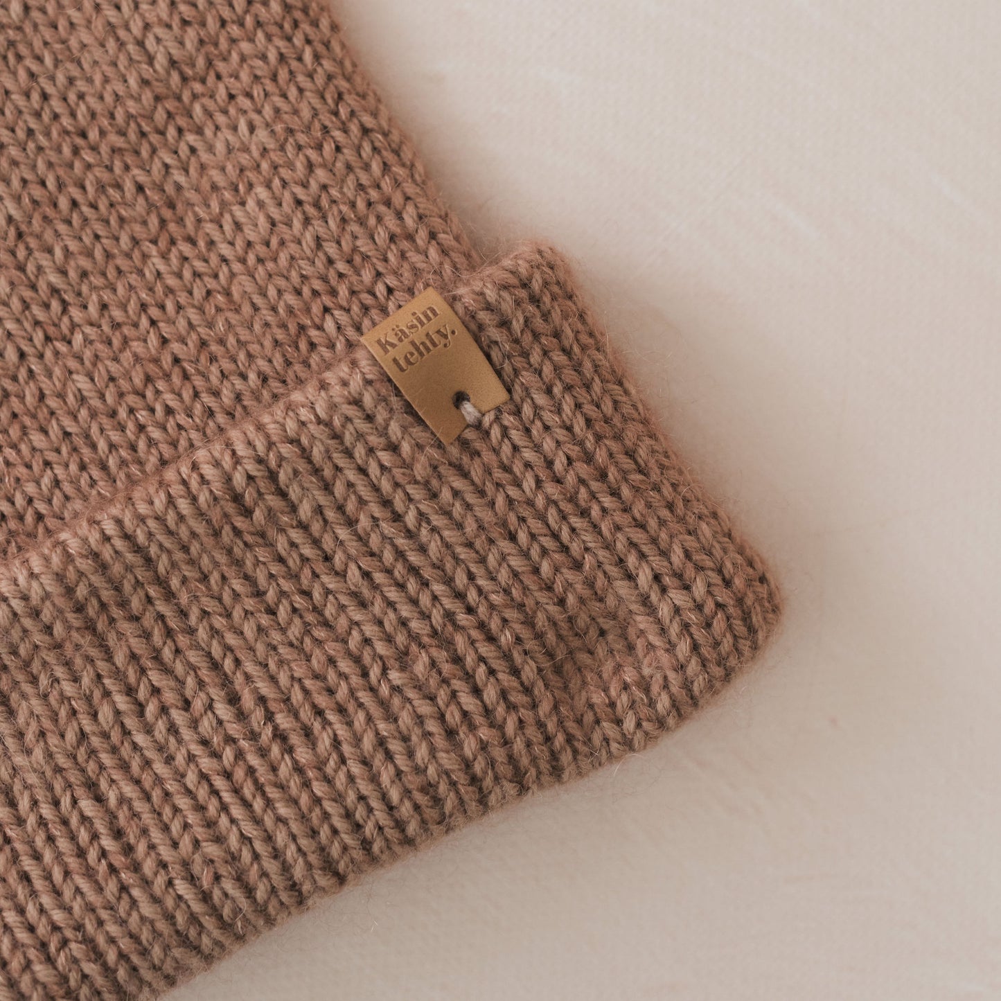 Brown knitted fabric with a brand label on a white background