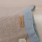 Close-up of a textured fabric with a label on a beige background
