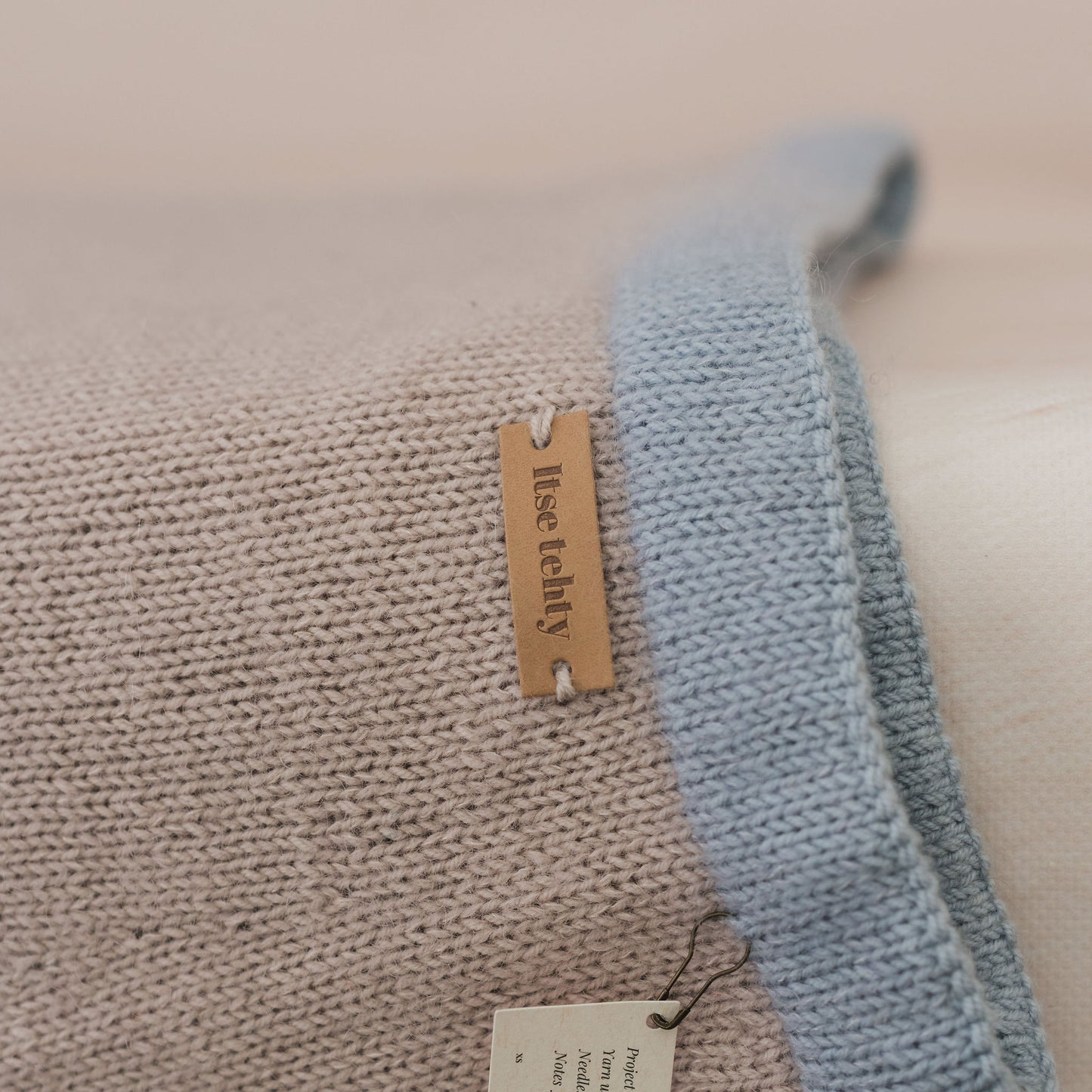 Close-up of a textured fabric with a label on a beige background
