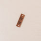 Brown leather tag with 'itse tehy' text on a beige background