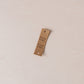PU leather paper tag with text "käsin tehty" on a light beige fabric background