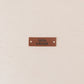 Brown leather label with text on a beige background, äidin tekemä