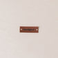 Brown leather label with 'Handgjord' text on a beige fabric background