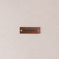 Brown leather label with 'Handmade' text on a beige fabric background