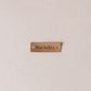 Tan coloured tag with 'Itse tehty' text on a beige background
