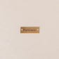 PUI leather tag with engraved text on a beige background, into this went all my patience
