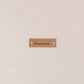 Brown label with 'Hermoni' text on a textured beige background