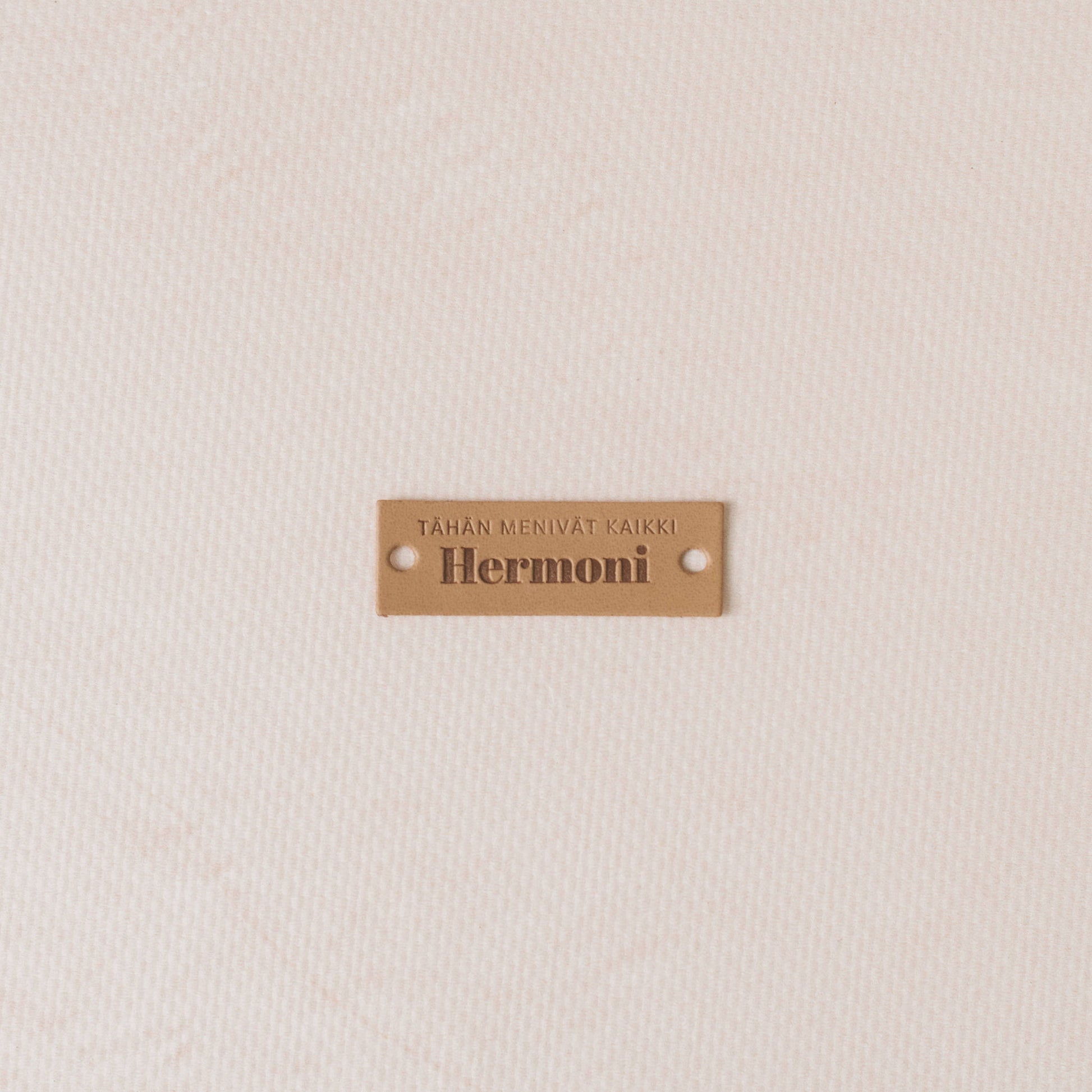 Brown label with 'Hermoni' text on a textured beige background