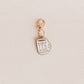A small gold charm shaped like a teacup with the text 'A CUP OF TEA SOLVES EVERYTHING" in gold lettering, shown on a textured off-white background.