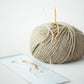 Ball of yarn with a knitting needle on a light surface